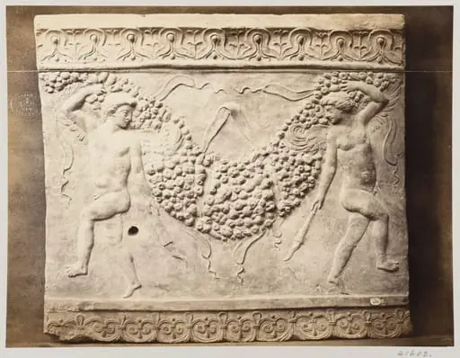 Bas-relief of portion of frieze of dancing figures with torches bearing festoon of fruit in terra cotta