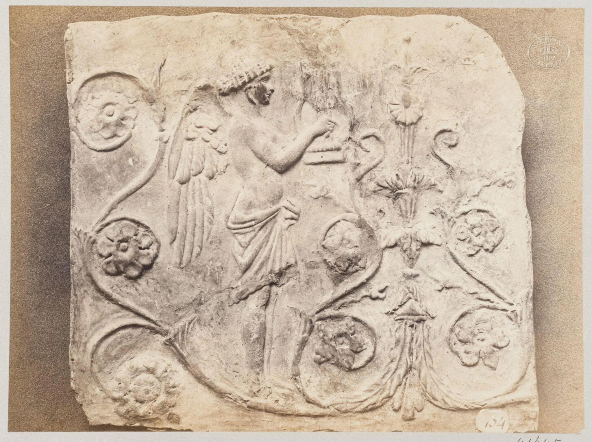 Bas-relief of a geni and a lyre in terra cotta