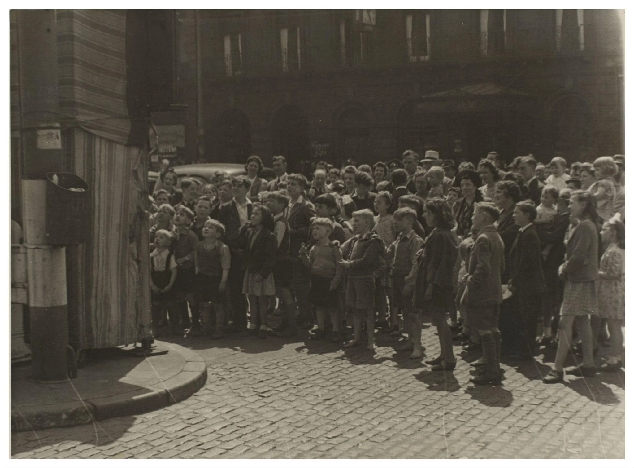 The audience at Professor Richard Codman lll's Punch and Judy booth, Liverpool, ca.1940, by Waldo S. Lanchester, photographic, 1940