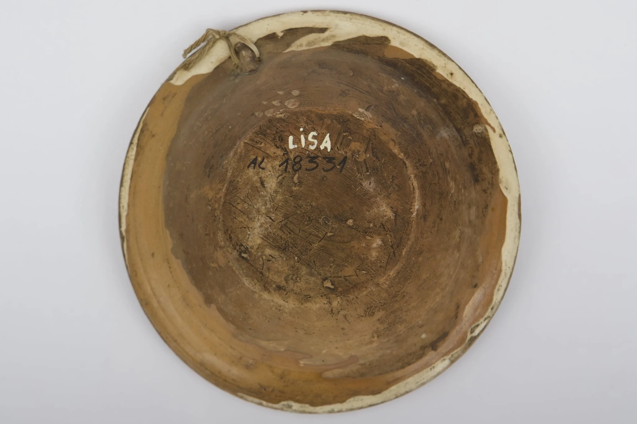 Vas ceramic smălțuit la interior, de formă tronconică, cu fundul plat, pereții ridicați și marginea evazată. Farfuria prezintă decor geometrizant și fitomorf stilizat. Pe fundul vasului, peste stratul crem de angobă, au fost realizate patru flori maro, cu mijlocul verde și albastru, fiind mărginite de patru grupuri a câte nouă puncte verzi și albastre (două câte două, în diagonală). Cel de-al doilea registru pictural a fost realizat marginal, pe buza piesei; fiind încadrat între două linii circulare drepte un șir de „V-uri” succesive. Farfuria era folosită în gospodărie pentru decorarea interioarelor sau servirea hranei. Prezintă uzură funcțională: Cromatică: fond: cărămiziu; crem; motive: maro; verde; albastru., by Unknown, unspecified, 1850