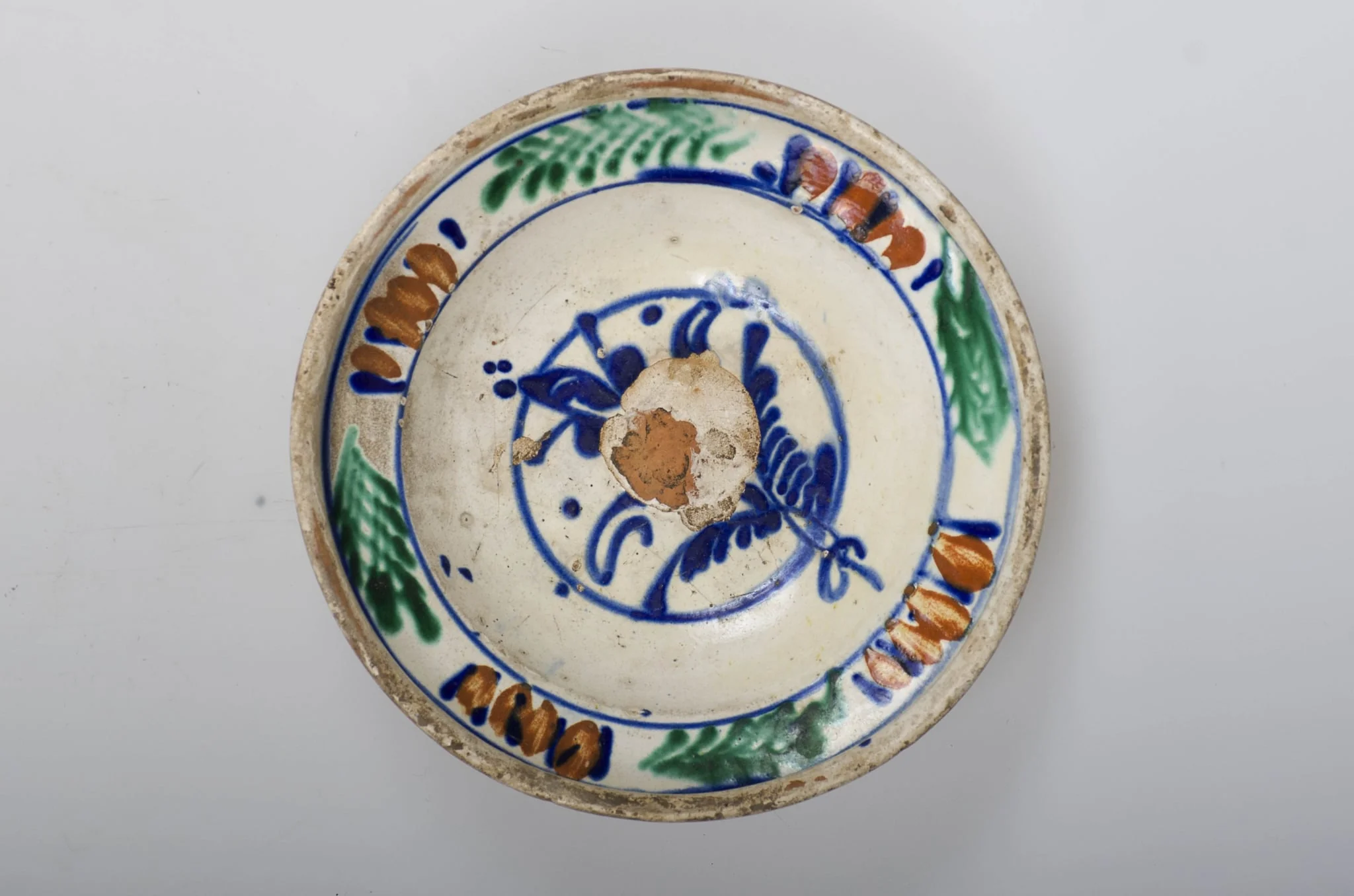 Vas de formă tronconică adâncit, smălțuit în interior cu buză profilată spre exterior. Este decorat în interior cu motive vegetale și florale (motivul brăduțului) dispuse într-un registru circular pictat pe în zona diametrului maxim al vasului. Cromatică: fond cărămiziu (exterior) cu scurgeri de smalț alb spre baza vasului; fond crem (interior); albastru; maro; verde; galben., by Unknown, 1850