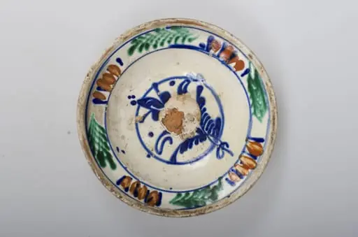 Vas de formă tronconică adâncit, smălțuit în interior cu buză profilată spre exterior. Este decorat în interior cu motive vegetale și florale (motivul brăduțului) dispuse într-un registru circular pictat pe în zona diametrului maxim al vasului. Cromatică: fond cărămiziu (exterior) cu scurgeri de smalț alb spre baza vasului; fond crem (interior); albastru; maro; verde; galben.