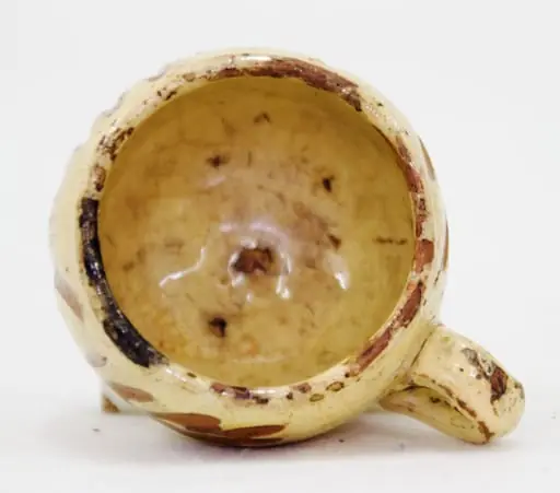 Piesa are o formă relativ cilindrică cu toartă. Are fundul îngustat și buza răsfrântă spre interior. Decorul este realizat prin incizie și pictare cu motive vegetale (crenguțe). Cromatică: galben lămâie (fondul), maro închis (decorul).