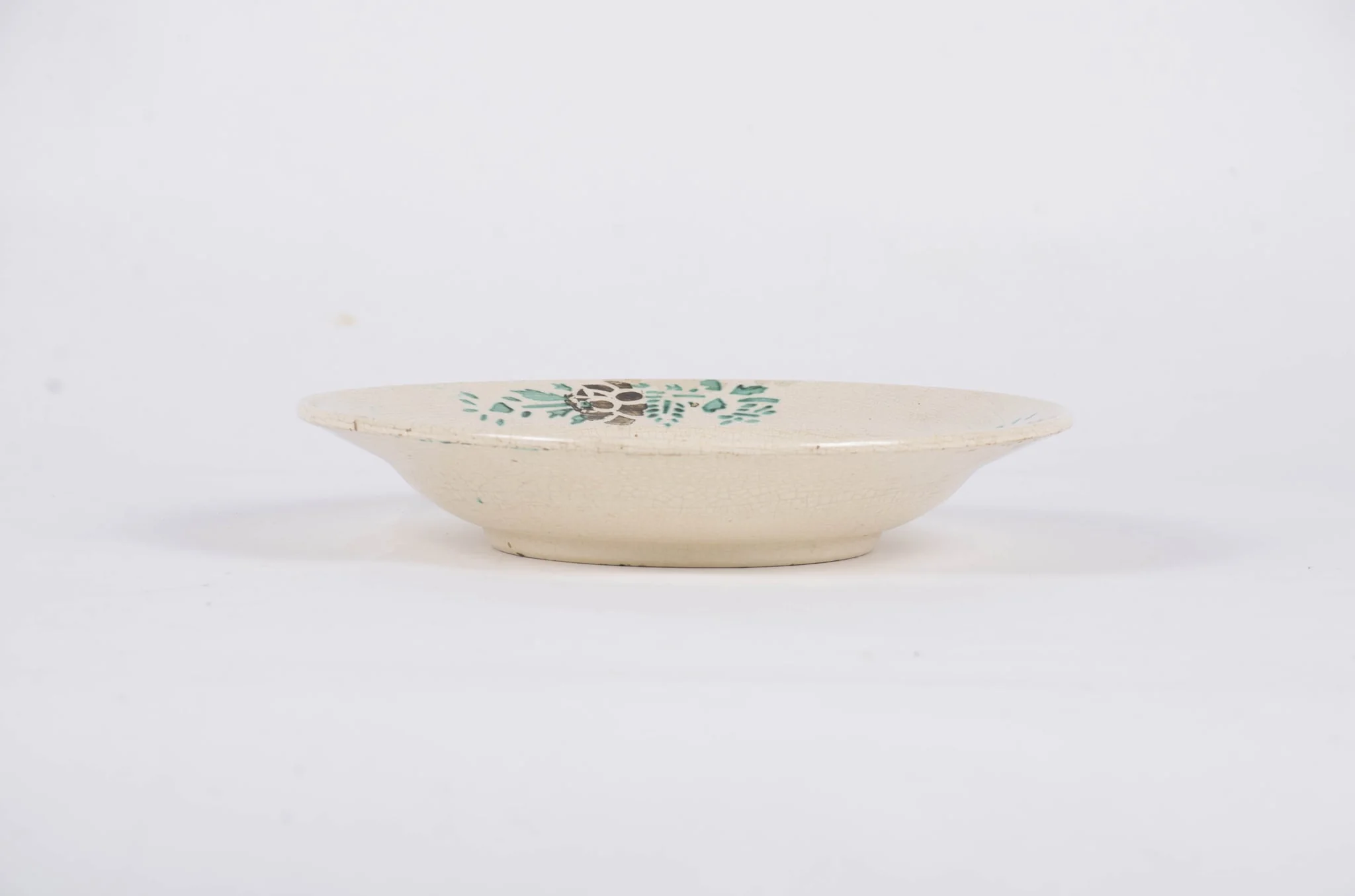 Farfuria este de formă tronconică fiind decorată cu motive florale dispuse central sub forma unui buchet de flori. Pe marginea piesei sunt dispuse într-un registru circular motive floral-vegetale pe un fond alb. Farfuria este smălțuită. Cromatică: fond: alb; motive: verde; maro., by Unknown, 1850