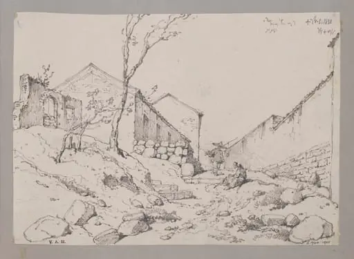 A path leading uphill between houses and a long wall