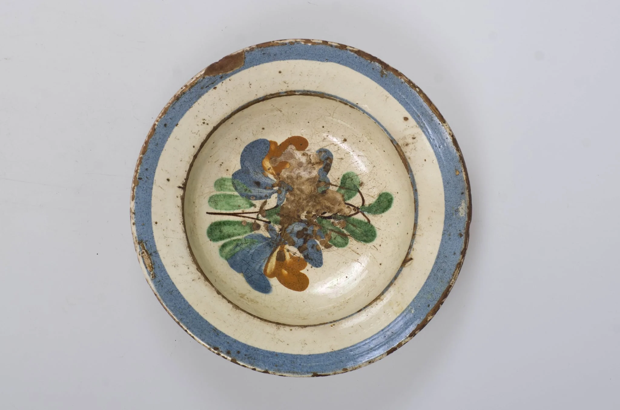 Vasul are formă tronconică, adâncit. Este smălțuit în interior și decorat cu motive floral-vegetale pe fundul vasului și pe margine cu motive geometrice realizate sub forma a trei cercuri concentrice, unul dintre cercuri mai îngroșat și dispus pe buza vasului. Cromatică: fond cărămiziu (exterior); fond alb (interior); albastru; verde; maro., by Unknown, 1850