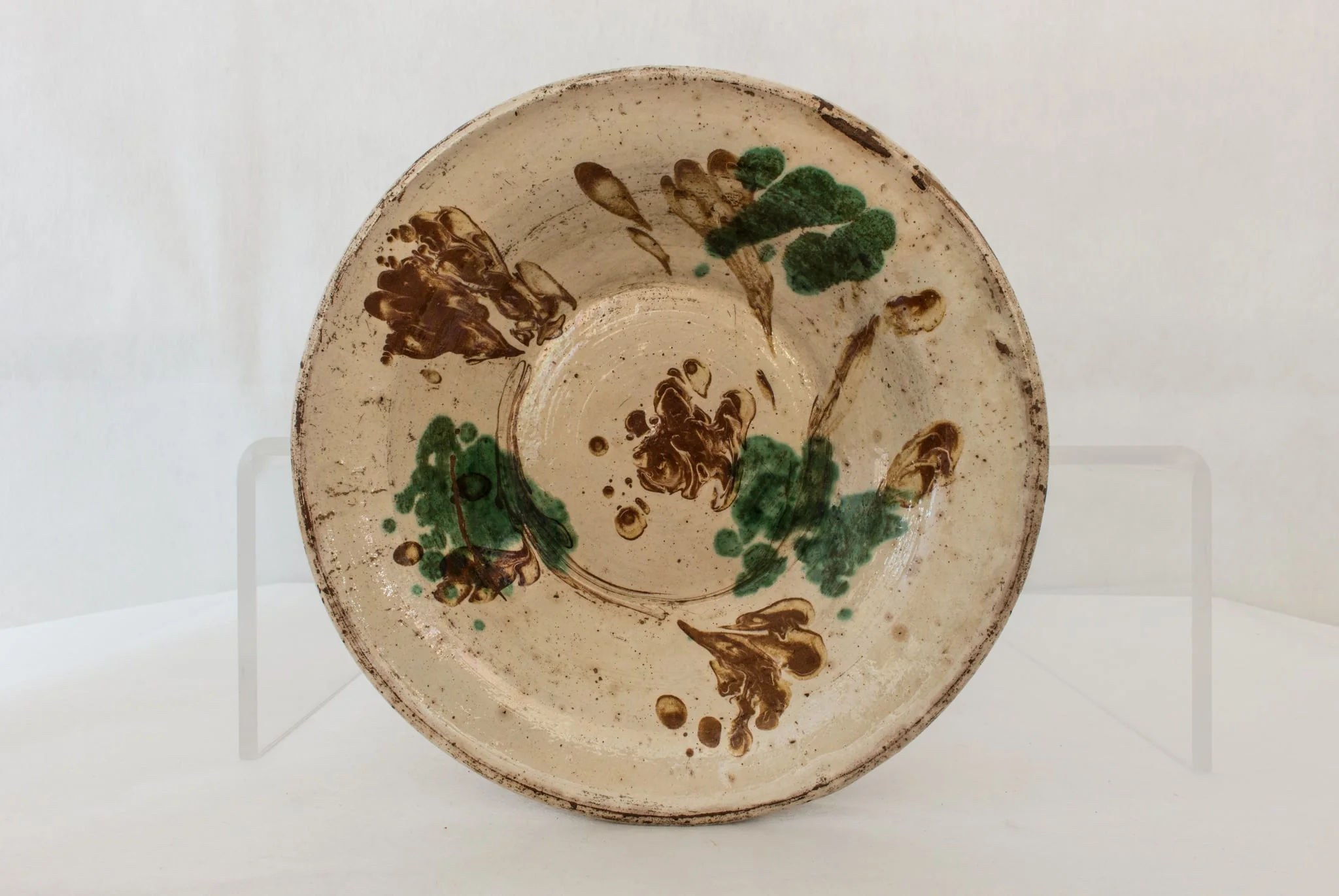 Vas de formă rotundă, adâncită, cu pereții evazați, smălțuit în interior, cu marginea ușor rotunjită, cu decor abstract realizat în tehnicile stropirii și scurgerii dirijate a colorantului maro. Cromatică: verde, maro, bej., by Unknown, 1850