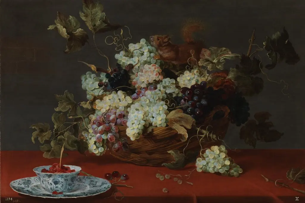 A fruit still life with a basket of grapes and a squirrel on a table