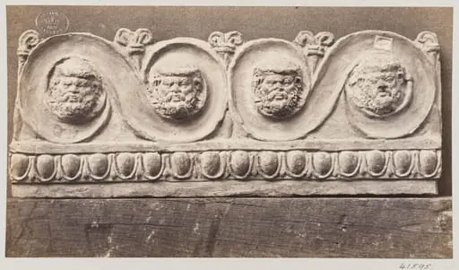 Bas-relief scroll with four masques in terra cotta
