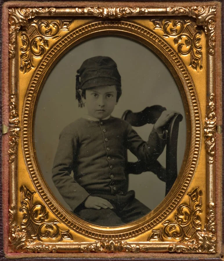 Seated boy in tasseled cap, by Unknown, 1860