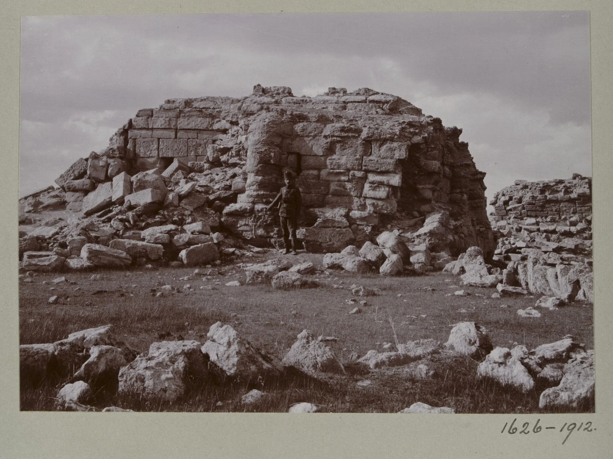 Photograph of a a ruined temple with a Turkish soldier in the Great Iwan at Hatra, Iraq