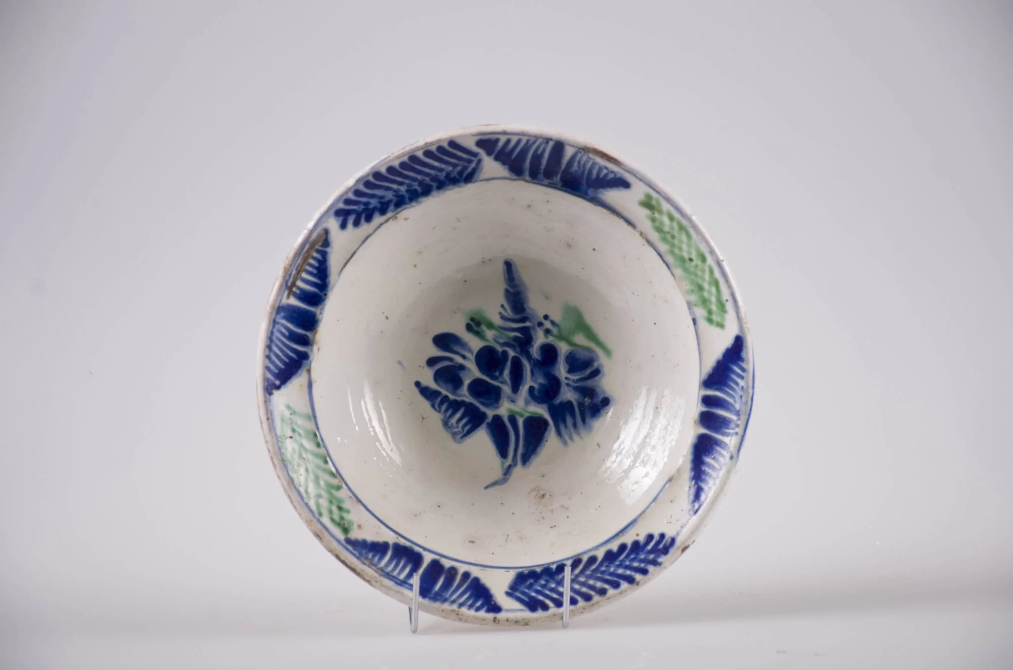 Blid de formă tronconică cu buza evazată, Smălțuit la interior. Decorul este format din ornamente florale dispuse pe motiv central: floare; motive marginale, fitomorfe: brăduț. Cromatică: verde și albastru pe fond alb., by Unknown, 1850