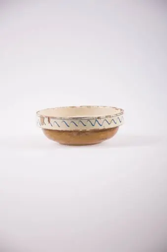 Vas de formă tronconică cu fundul ușor profilat, buza dreaptă și evazată. Smălțuit în interior și în exterior. Motiv ornamental central este floral. În exteriorul buzei avem motiv geometric în formă de val. Cromatică: fond: alb; motive: alb; verde; albastru; maro.