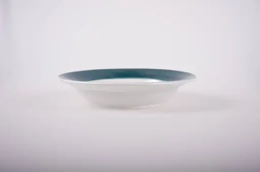 Farfurie de formă tronconică, adâncită; pe fund are găuri pentru agățare. În centru este decorată cu motive florale; marginea este pictată verde; pe fund are trei cercuri concentrice. Cromatică: fond: alb; motive: verde; vișiniu; albastru; galben.