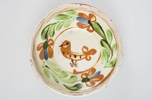 Blid de formă tronconică cu buza înaltă, smălțuit pe interior. Acesta este ornamentat cu motive florale, avimorfe, liniare și curbilinii, realizate prin pictare cu pensula. Pe buza interioară a vasului se identifică motivul geometric al liniei vălurite succedat de motive curbilinii care încadrează un registru floral-vegetal continuu dispus pe zona mediană a vasului. De asemenea, se identifică un motiv avimorf pictat pe fundul vasului și încadrat de un cerc. Obiectul este smălțuit la exterior doar pe buză, pe exteriorul buzei fiind incizate două linii. Fundul este inelar, prevăzut cu două orificii pentru agățare. Se identifică scurgeri insulare de smalț pe exteriorul buzei. Pe exterior se profilează, în zona diametrului maxim, un brâu continuu obținut prin lucrarea la roată. Cromatică: fond: alb (la interior); cărămiziu (exterior); motive: cărămiziu; verde; maro; albastru.