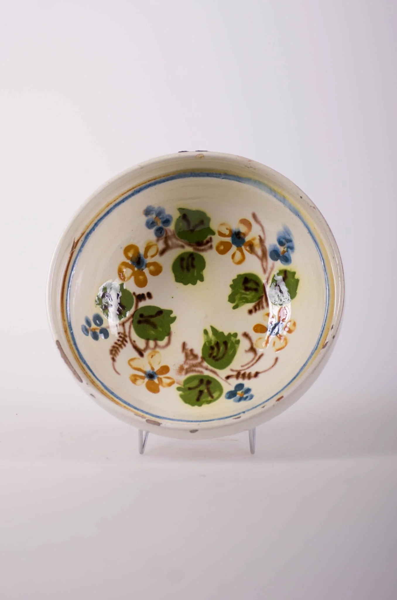 Farfurie de formă tronconică, adâncită, cu buza foarte înaltă; pe fund are găuri pentru agățare. Este smălțuit în interior și exterior (buza). Decorat cu motive geometrice: linie; motive fitomorfe; motive florale. Cromatică: fond: alb; motive: verde; maro; albastru.