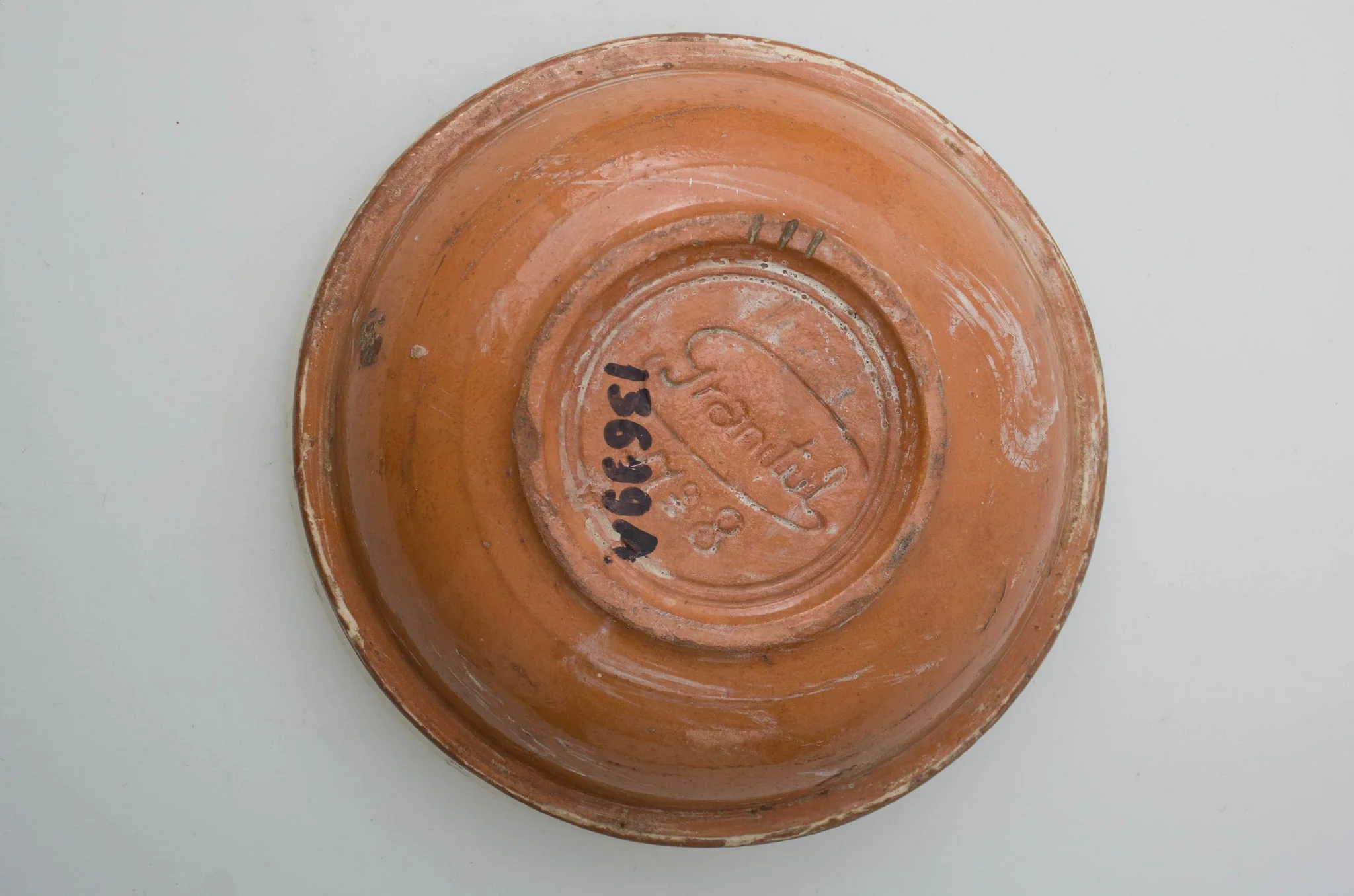 Vas ceramic smălțuit, de formă circulară cu profil tronconic, având pereții ușor evazați, baza plată și buza circulară. Decorat cu motive vegetal-florale și cordiforme pe fundul vasului (două rânduri de frunze, o lalea și o inimă), pictate cu pensula. Fundul vasului este delimitat de pereți printr-o linie subțire, circulară. Gura este pictată în alb și la exterior.Pe fundul vasului găsim marca Granitul No 8 și două cercuri concentrice, incizate. Cromatică: fond alb interior, cărămiziu și alb exterior; motive: albastru, cărămiziu, verde, maro., by Unknown, 1850