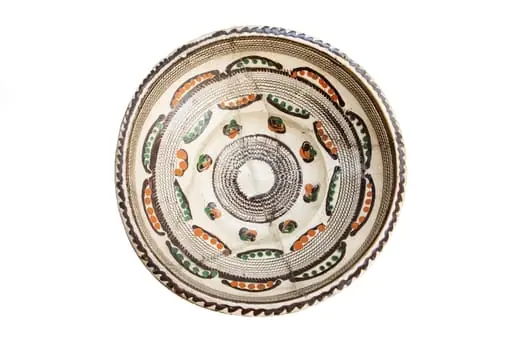 Formă tronconică; fond alb fildeșiu; pe fundul vasului este dispusă o bandă circulară lată decorată cu motivul specific centrului: pînza de păianjen - realizată prin tehnică jirăvirii cu gaița, încadrată de boboci de floare stilizați, colorați în verde și cărămiziu și linii ușor curbate care au interior puncte de culoare cărămizie, respectiv: verde. Pe umărul vasului este dispusă o altă bandă circulară jirăvită cu motivului pînzei de păianjen care prezintă în exterior linii curbe similare cu cele descrise mai sus. Întreaga compoziție sugerează un soare stilizat. Buza este decorată cu un val circular de culoare brună. Piesa reprezintă una dintre primele achiziții ale lui Alexandru Tzigara Samurcaș. Folosită la decorarea interiorului țărănesc în așa numita - cameră bună
