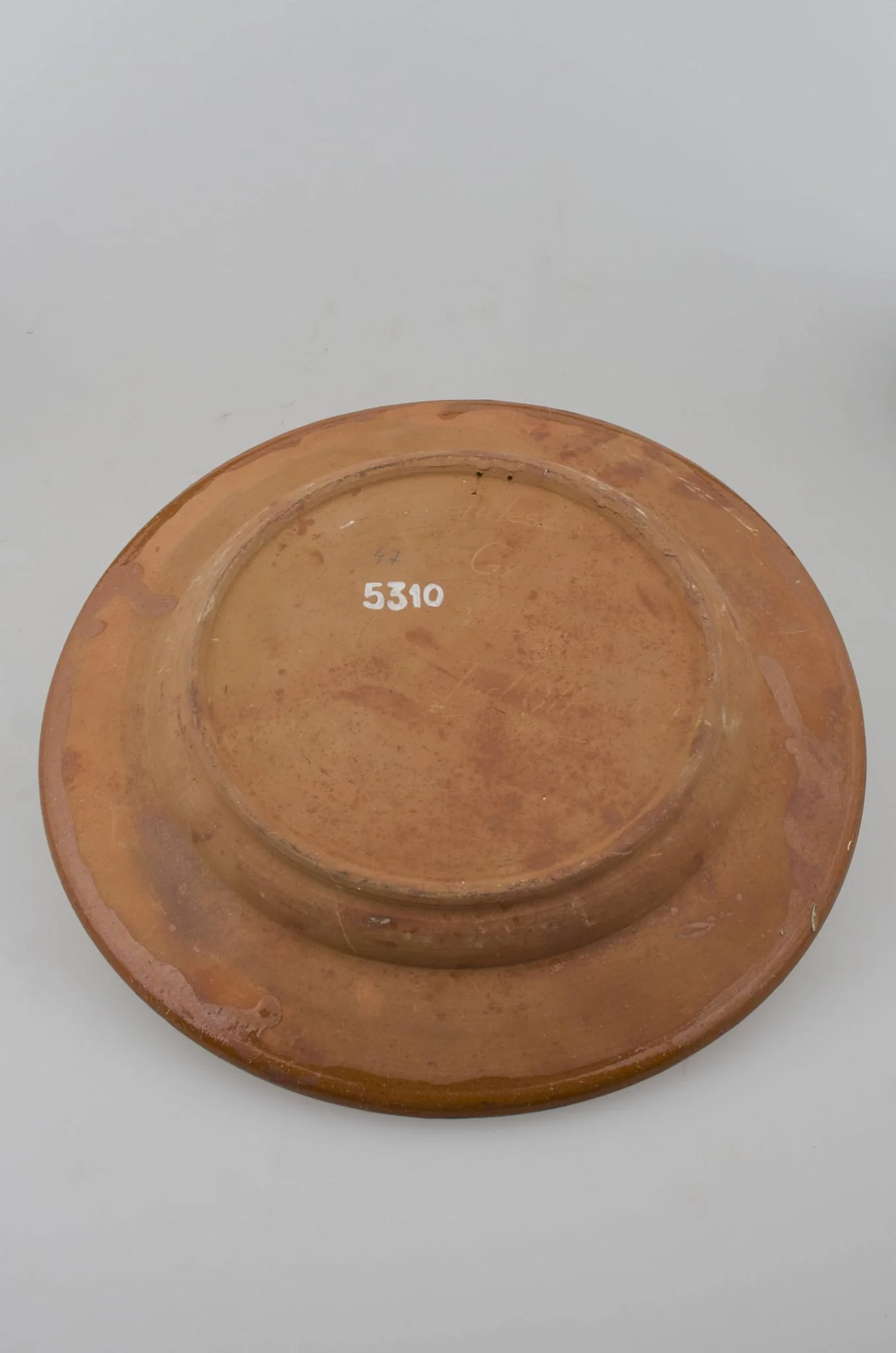Blid tronconic cu fund plat, margine puțin ridicată și buza ușor oblică. Decor cu motive aviforme și florale: cocoș pe centru și o floare; pe margine, circular, motive geometrice (semicercuri, liniare, punctate, zig-zag). Cromatică: fond: cărămiziu; motive: maro; verde; alb; galben.