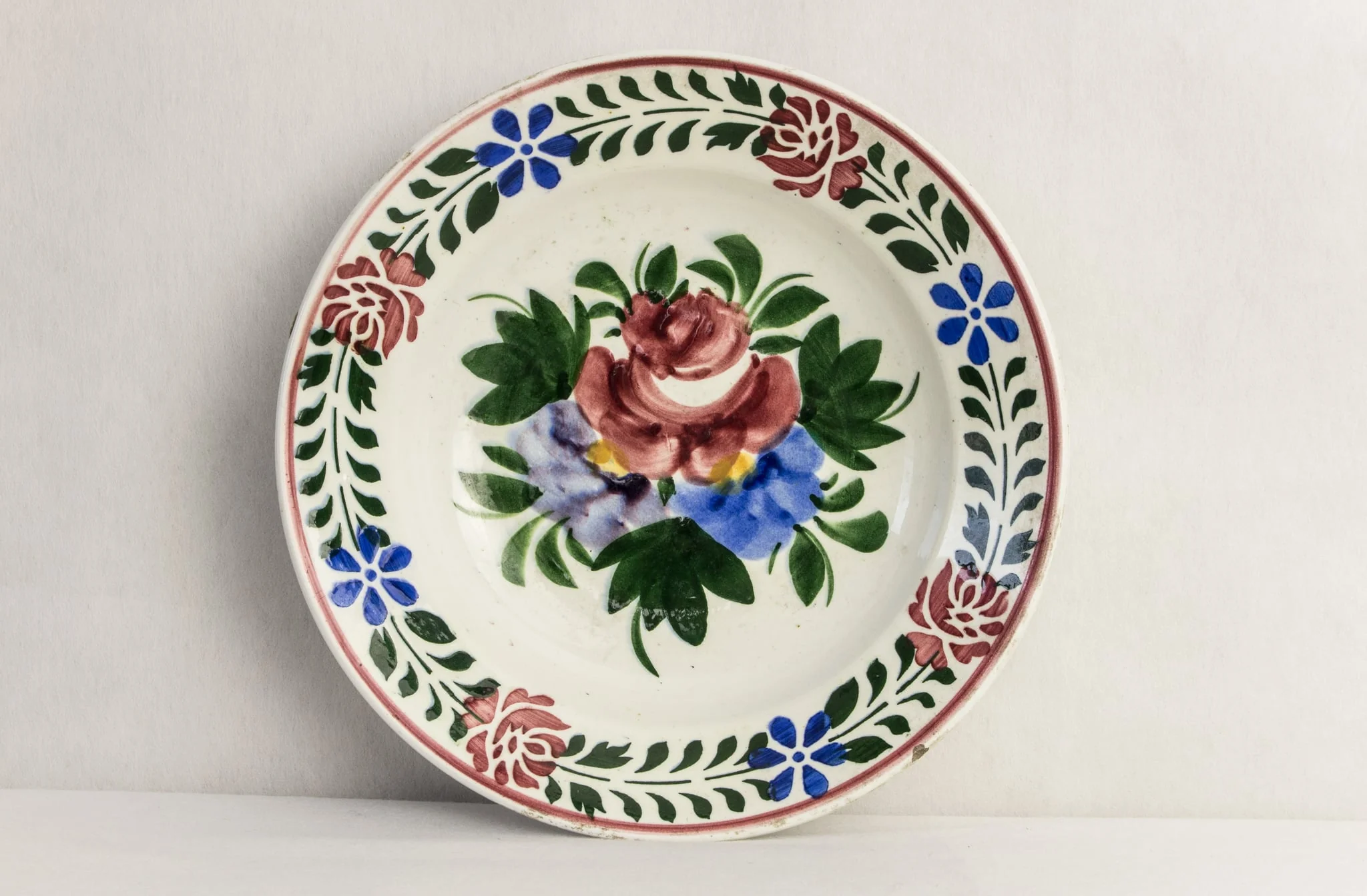 Vas de formă rotundă, smălțuit în interior și exterior, decorat pe suprafața interioară prin pictare manuală astfel: central, un motiv floral reprezentând buchetul cu flori; pe margine, motive florale dispuse circular (trandafiri și albăstrele). Pe fundul vasului este prezentă marca manufacturii din Hollóháza (inscripția Magyar. Gyártmányi 10 și casa cu corb). Cromatică: alb, albastru, verde, galben, roșu., by Magyar. Gyártmányi