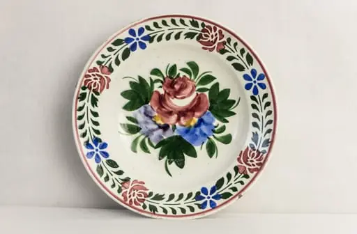 Vas de formă rotundă, smălțuit în interior și exterior, decorat pe suprafața interioară prin pictare manuală astfel: central, un motiv floral reprezentând buchetul cu flori; pe margine, motive florale dispuse circular (trandafiri și albăstrele). Pe fundul vasului este prezentă marca manufacturii din Hollóháza (inscripția Magyar. Gyártmányi 10 și casa cu corb). Cromatică: alb, albastru, verde, galben, roșu.