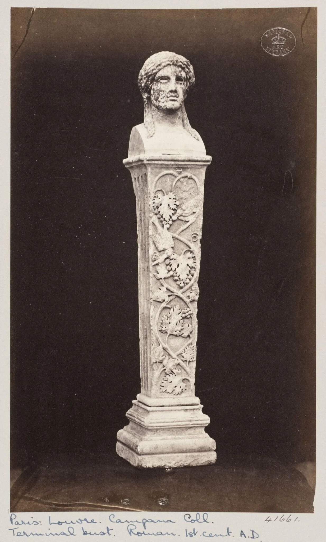 Marble herma with the head of Baccus ornamented with vine leaves and fruit