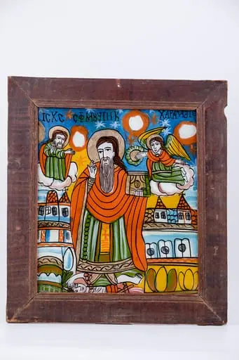 Sfântul Mare Mucenic Haralambie, făcător-de-minuni, este cel mai bătrân mucenic din cei prăznuiți de creștini. Este cunoscut ca și făcător-de-minuni, vindecător de boli și ocrotitor al caselor familiilor creștine. Central este pictat Sfântul, îmbrăcat cu veșminte liturgice, arhierești, cu sacos verde-văratic, felon roșu vermillon și epitrahil galben, cu o cruce mică orange, cu aureolă. Fiind foarte bătrân, are barbă albă, lungă sură și părul șaten-castaniu lăsat pe umeri. În mâna stângă are Sfânta Evanghelie închisă și cu mâna dreaptă Binecuvântează, și ține în lanț ciuma, reprezentată antropomorfic. Ciuma, simbolizând boala incurabilă și moartea, are secera în mână și coarne de diavol, fiind, totodată și păcatul, patima, aducătoare de moartea duhovnicească. În registrul superior, în dreapta este Dumnezeu-Tatăl Binecuvântând, de pe o mandorlă de nouri albi-crem și în stânga sfântului ierarh, este un înger îngenuncheat pe un nor, cu aripile galbene, care așează cununa de mucenicie pe capul Sfântului Haralambie. În registrul inferior, este o alternanță de câmpuri galbene-verzi cu elemente florale de câmp, iar în registrul mediu sunt elemente de arhitectură. Fondul icoanei este cerul albastru regal cu steluțe albe-roșii, astfel creându-se o simetrie compozițională. Cromatica este armonioasă: albastru regal, cobalt, roșu vermillon, galben chihlimbar, verde văratic, brun, bej, crem, alb, negru se întrepătrunde estetic cu detaliile minuțioase ale desenului. Inscripția din româno-chirilică se traduce IC XC Iisus Hristos Sf Mucenic Haralambie. Icoana este din Țara Oltului, Șcheii Brașovului.