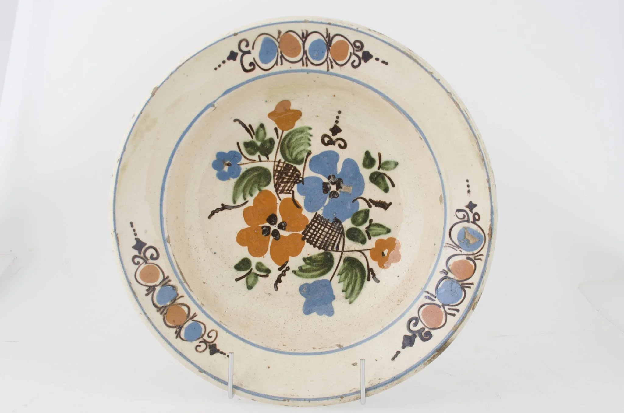 Farfuria este lucrată la roată, prezintă marginea evazată în plan orizontal fiind smălțuit în interior. Pe suprafața interioară a vasului se identifică registre decorative floral-vegetale dispuse pe fundul vasului și pe marginea interioară. Registrele sunt delimitate de două cercuri realizate prin pictare și dispuse pe buza vasului și spre interiorul acestuia. Cromatică: fond: alb; motive: roșu; albastru; verde; brun; maro.