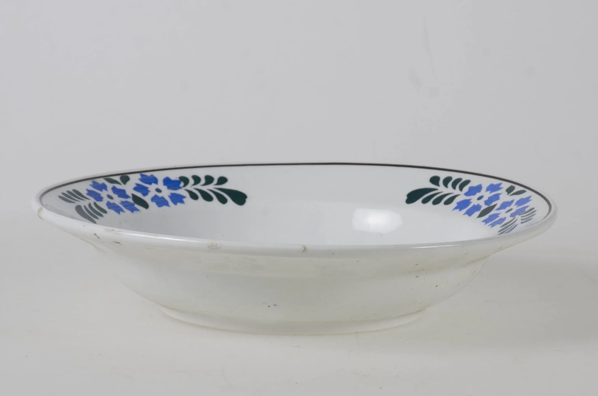 Vasul are formă tronconică smălțuit la interior și pe exterior (smalț de culoare albă). Prezintă motive decorative floral/vegetal și geometrice dispuse pe fundul vasului dar și într-un registru decorativ dispus pe buza vasului. De asemenea se identifică și motive decorative geometrice: pătratul, cercul, linia. Cromatică: fundal alb; verde; grena; albastru., by Unknown, 1850