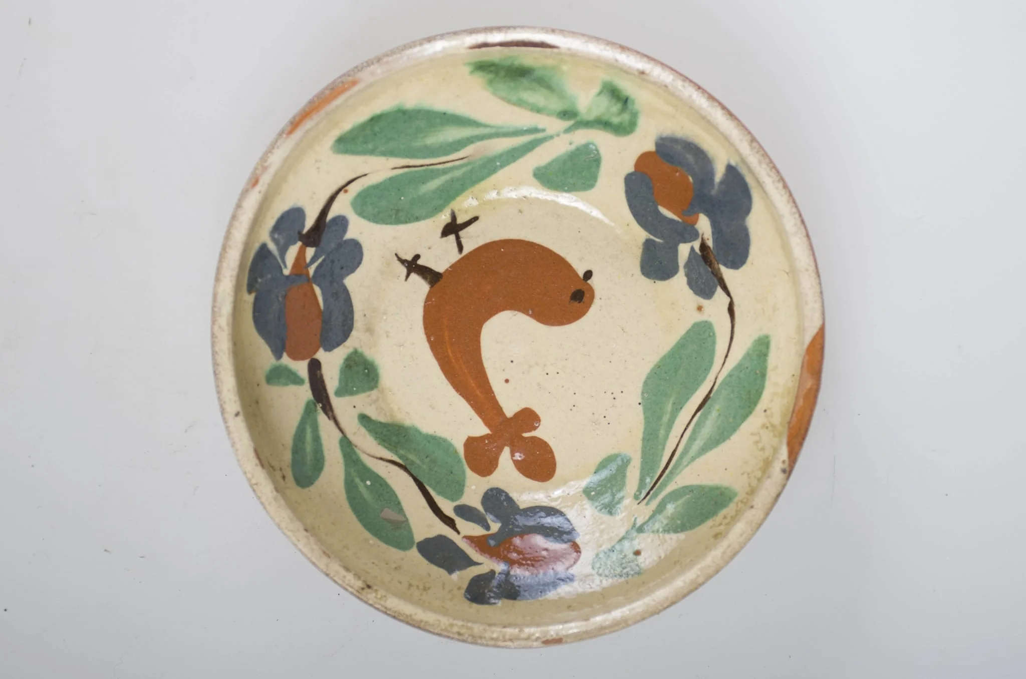Blidul de formă tronconică este adânc, smălțuit (la interior). Vasul este ornamentat cu motive florale și avimorfe, cu buza înaltă, neornamentat și nesmălțuit la exterior. Cromatică: fond: maro-roșcat (exterior); alb (interior); decor: verde; maro; albastru; negru., by Unknown, 1850