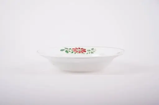 Farfurie de porțelan de formă tronconică, smălțuită în interior și la exterior. Pe fond alb avem flori stilizate (margarete). Buza farfuriei este conturată de o dungă neagră, iar pe margini sunt flori vișinii cu frunze verzi; în interiorul farfuriei pictate avem două flori mari (vișinii) și frunze verzi.