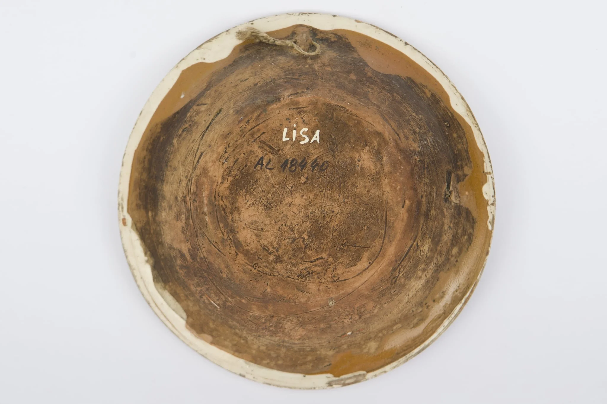 Recipient ceramic smălțuit la interior, de formă tronconică, cu baza plată, pereții înalți și marginea profilată. Peste stratul crem de angobă a fost pictat decorul geometrizant și fitomorf stilizat: Pe fundul vasului au fost realizate patru flori maro, cu mijlocul verde și albastru, fiind mărginite de patru grupuri de câte nouă puncte verzi și albastre (două câte două, în diagonală). Cel de-al doilea registru pictural a fost realizat marginal, pe buza piesei fiind încadrat între două linii circulare drepte un șir de „V-uri” succesive. Farfuria era folosită în gospodărie pentru decorarea interioarelor sau servirea hranei. Prezintă uzură funcțională: Cromatică: fond: cărămiziu; crem; motive: maro; verde; albastru., by Unknown, unspecified, 1850