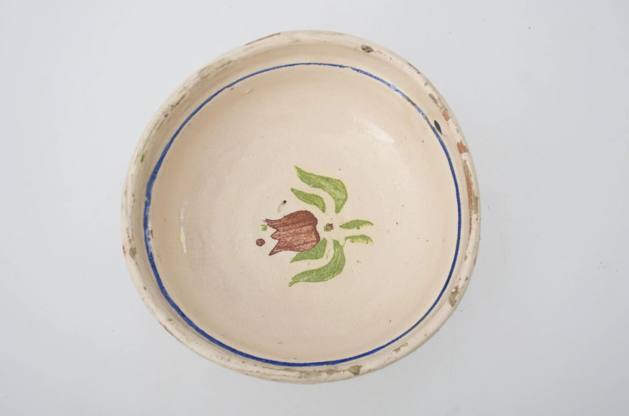 Blid de formă tronconică, adâncită; este smălțuit interior și exterior (doar buza); este decorat cu motive geometrice pe margine: linie; în centru este decorat cu motive florale: lalea. Cromatică: fond crem, maro, verde, albastru., by Unknown, 1850