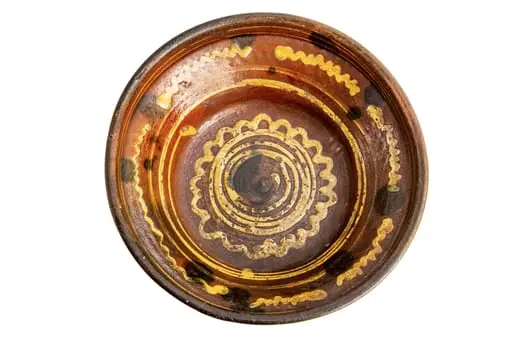 Formă tronconică; fond cărămiziu; culori: galben, verde, brun. În centru este amplasată o spirală de culoare galbenă trasată cu cornul înscrisă într-un val circular de culoare similară care sugerează un soare; pe perete strachinei sînt amplasate șase segmente de linie vălurită de culoare galbenă și pete de culoare brună.