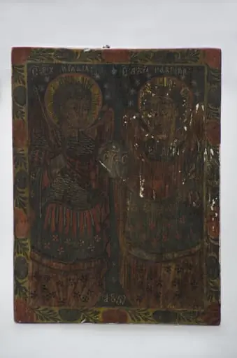 Icoană pe lemn, datată 1839, reprezentând pe Sfinții Arhangheli Mihail și Gavriil ținând în mână globul pământesc pe care sunt literele „S S S (Sfânt Sfânt Sfânt)” - cântarea îngerilor din ceruri. În registrul superior sunt scrise numele îngerilor în românește cu caractere chirilice: „Sf Arh Mihail – Sf Arh Gabriil”. Cu îmbrăcăminte ostășească, îngerii au aoreolă împrejurul capului, Mihail are sabie în mâna dreaptă iar Gavriil are crinul în mâna stângă. Icoana are un chenar realizat cu o linie subțire. Un al doilea chenar exterior cu motive florale și vegetale. Cromatică: roșu, alb, bleumarin; auriu; alb; negru.