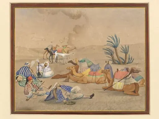 A caravan with camels resting at an oasis in the desert.
