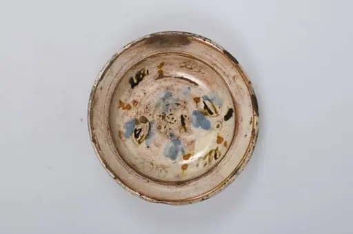 Vas de formă tronconică adâncit, smălțuit în interior. Este decorat pe margine cu motive geometrice: cercuri concentrice, iar în centru cu motive vegetale și florale. Decorul este realziat prin pictare. Cromatică: fond cărămiziu (exterior); fond alb (interior); albastru; maro; portocaliu.