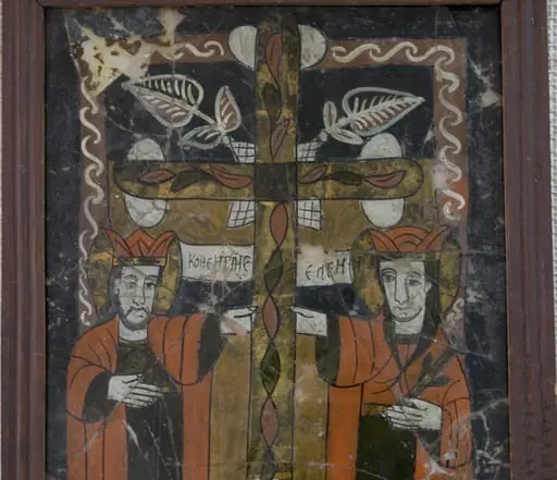 Pictură în oglindă, pe spatele unei bucăți de glajă, ax vertical.Sfinții Împărați Constantin și Elena, 3/4 , în picioare, semiprofil, sub brațele crucii pe care a fost răstignit Isus( găsită de Împărăteasa Elena la Ierusalim) Amândoi au plete castanii, lăsate pe umeri, coroane înalte, veșminte identice, simple, lungi, cămăși verzi și mantii roșii. Plasarea personajelor sub brațele crucii, în jumătatea inferioară, pe fond ocru sugerează complementaritatea celor două planuri(terestru și ceresc). Împărăteasa ține în mână o ramură verde, element ce o însoțește în majoritatea reprezentărilor populare. Fețele sunt ușor diforme, ochii negri. Crucea dreaptă, plasată în centrul compoziției, decorată cu frunze și o spirală în partea de jos, creează simetrie. La întretăierea brațelor crucii elemente vegetale cu contur alb. Chenarul specific icoanelor de Nicula, linia albă(zăluțe, funie) pe fond roșcat. Icoana este caracteristică perioadei de înflorire a picturi pe sticlă de la Nicula. Rama profilată, din lemn de brad, pictată cu o culoare roșcată. Dosul subțire. Sticla spartă în mai multe fragmente.
