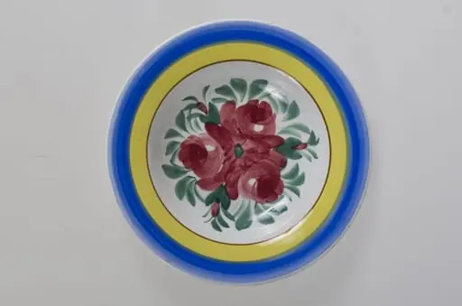 Farfurie de formă tronconică, adâncită; motive florale în centru (trandafiri); pe margine este decorat cu trei cercuri concentrice. Pe fund este o ștanță: o casă cu o pasăre pe acoperiș cu inscripție deasupra: ”MAGYAR” și dedesubt: ”1971” și un cuvânt indescifrabil. Pe fundul vasului sunt două incizii în care este introdus un șnur folosit la agățarea vasului pe perete. Vasul este smălțuit interior-exterior. Decor obținut prin pictare. Cromatică: fond: alb, motive: roșu; verde; albastru; galben.