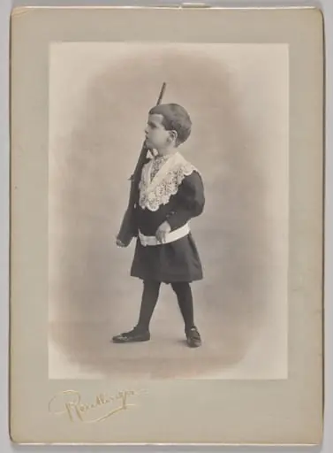Untitled (young boy with lace collar and toy rifle)
