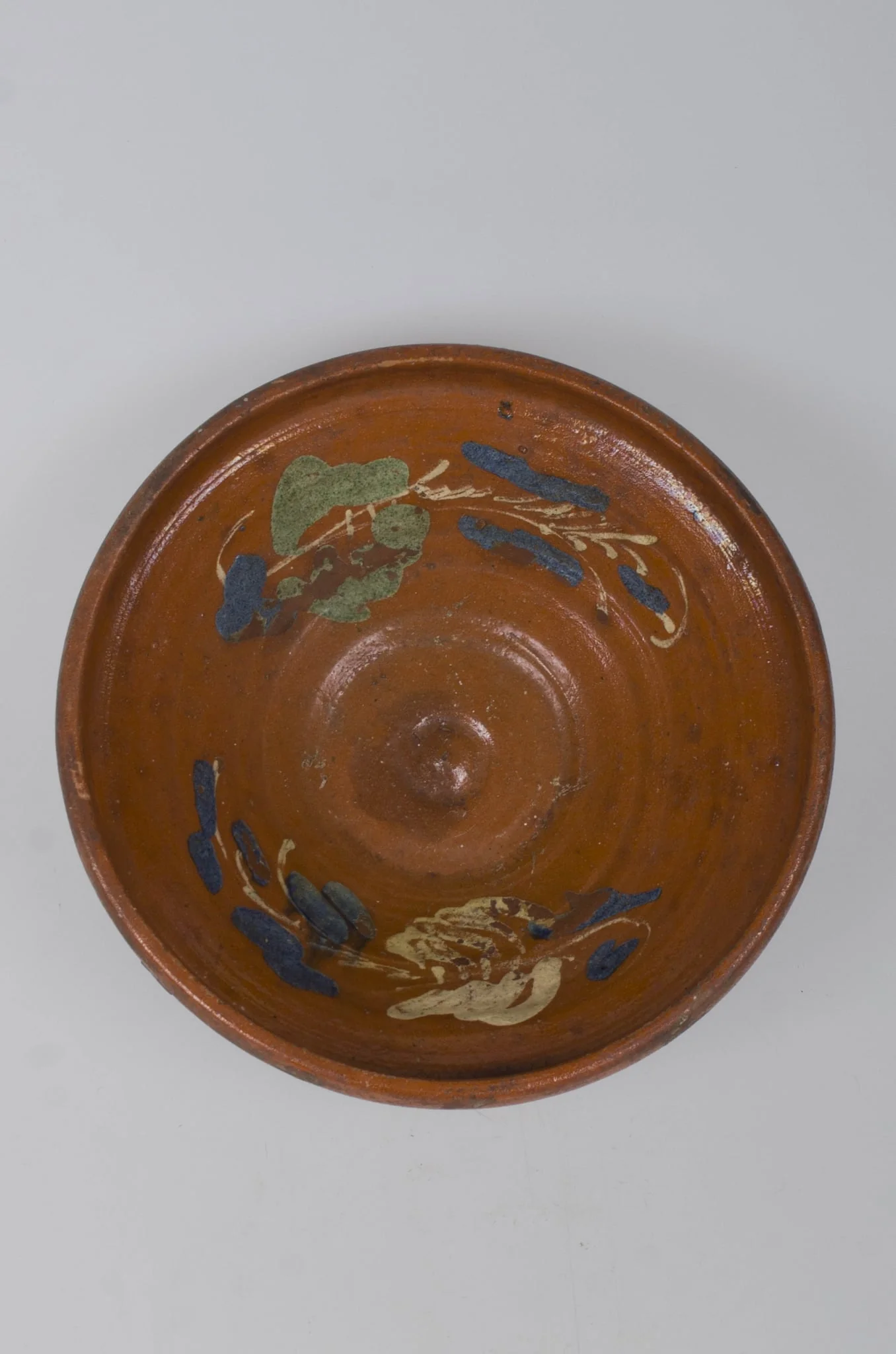 Castron de formă tronconică, adâncit. Marginea acestuia este foarte înaltă, fiind smălțuit în interior și exterior (buza). Pe margine este decorat cu motive vegetale și florale. Cromatică: fond cărămiziu; alb; verde; albastru. Castronul era folosit pentru depozitarea alimentelor., by Unknown, 1850