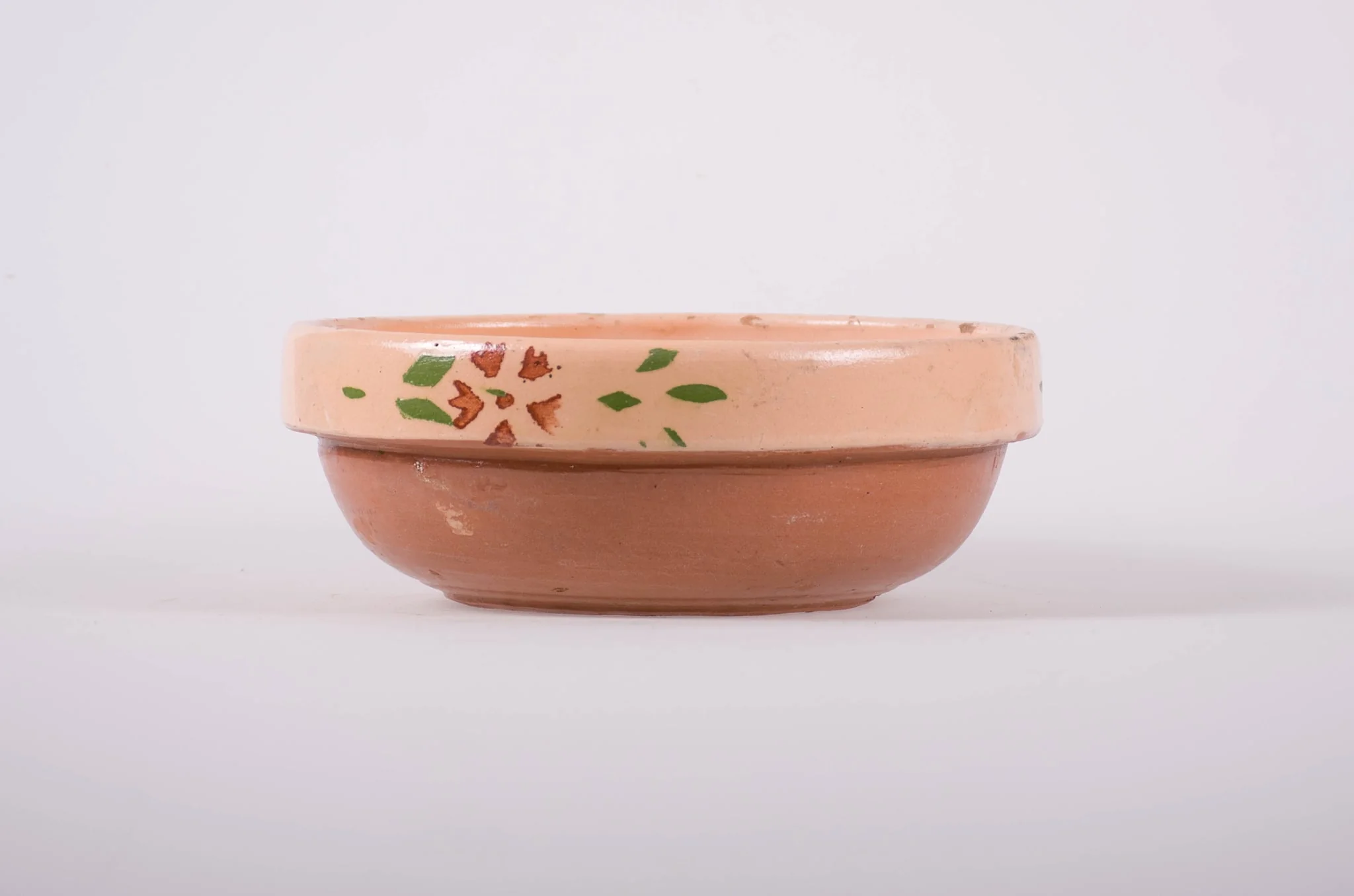 Vas de formă tronconică, adâncit, cu buza foarte înaltă; pe fund are găuri pentru agățare. Este smălțuit interior și exterior. Decorat cu motive geometrice: linie; motive florale. Cromatică: fond; crem; motive: maron; verde., by Unknown, 1850