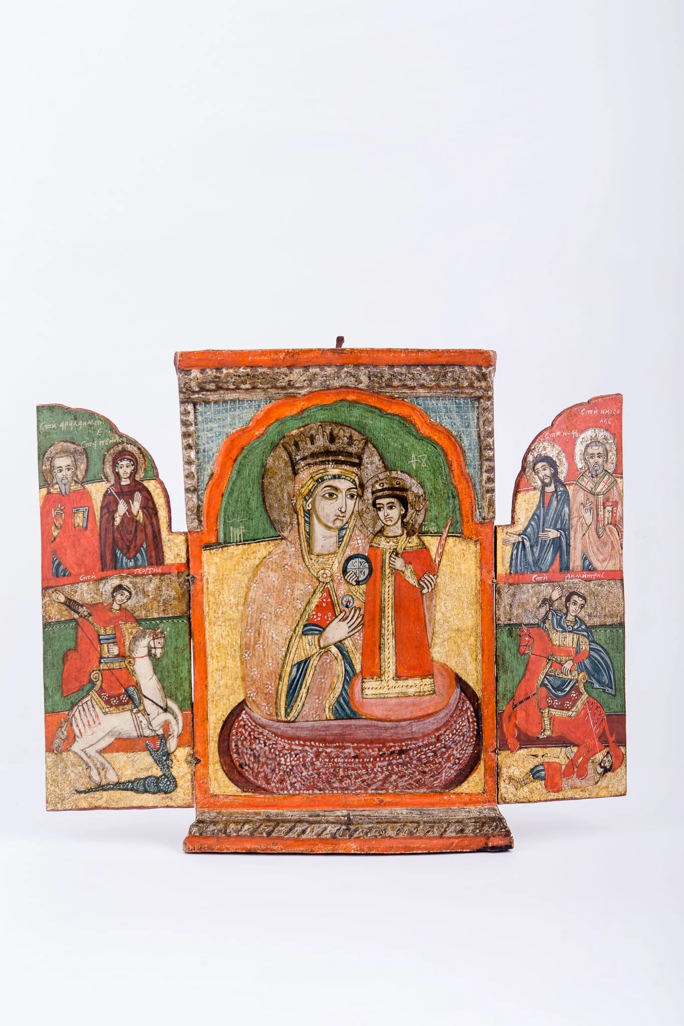 Icoana este un triptic - ansamblu de trei panouri pictate, unite prin conținut tematic iconografic comun și prin balamalele, prin care fețele laterale se închid de cea centrală. Tripticul este asemenea unei cărți sau ferestre, deschise-închise. Având stabilitate icoana centrală, tripticul poate avea valoarea de altar zburător. Tema centrală, care dă și titlul întregului ansamblu este Maica Domnului ține în brațe Pruncul Iisus Hristos, care Binecuvântează cu mâna dreaptă și ține globul pământesc cu crucea. Mântuitorul stă în picioare pe genunchii Maicii Domnului. Maica Domnului este înveșmântată în mantie cu maforion gălbui-crem-bej cu interiorul verde-roșu și ciupag auriu, are coroană și aureolă. Pruncul Iisus Hristos este înveșmântat în roșu sângeriu, cu bordură dantelată aurie, cu aureolă. Fondul icoanei este galben, în registrul inferior și verde în registrul superior. Icoana este încadrată de un chenar orange, portocaliu și un chenar crestat, basorelief, motivul funiei, de culoarea naturală a lemnului. În tematica fețelor laterale sunt reprezentați Sfântul Mare Mucenic Gheorghe purtător de biruință, Sfântul Mare Mucenic Dimitrie izvorâtor de mir, Sfânta Mare Cuvioasă Parascheva, Sfântul Ioan Botezătorul și doi sfinți ierarhi. Ușițe tripticului închizânduse, se realizează o imagine boltită, asemenea unor uși de biserică, pe care este inscripția în româno-chirilică: IC XC NIKA Iisus Hristos Biruiește! Cromatică: roșu vermillon, roșu-portocaliu, galben, verde, acajou, stacojiu, brun, bej,olive, auriu, negru. Inscripția pe icoana centrală, din româno-chirilică se traduce MP IC XC Maica Domnului Iisus Hristos.