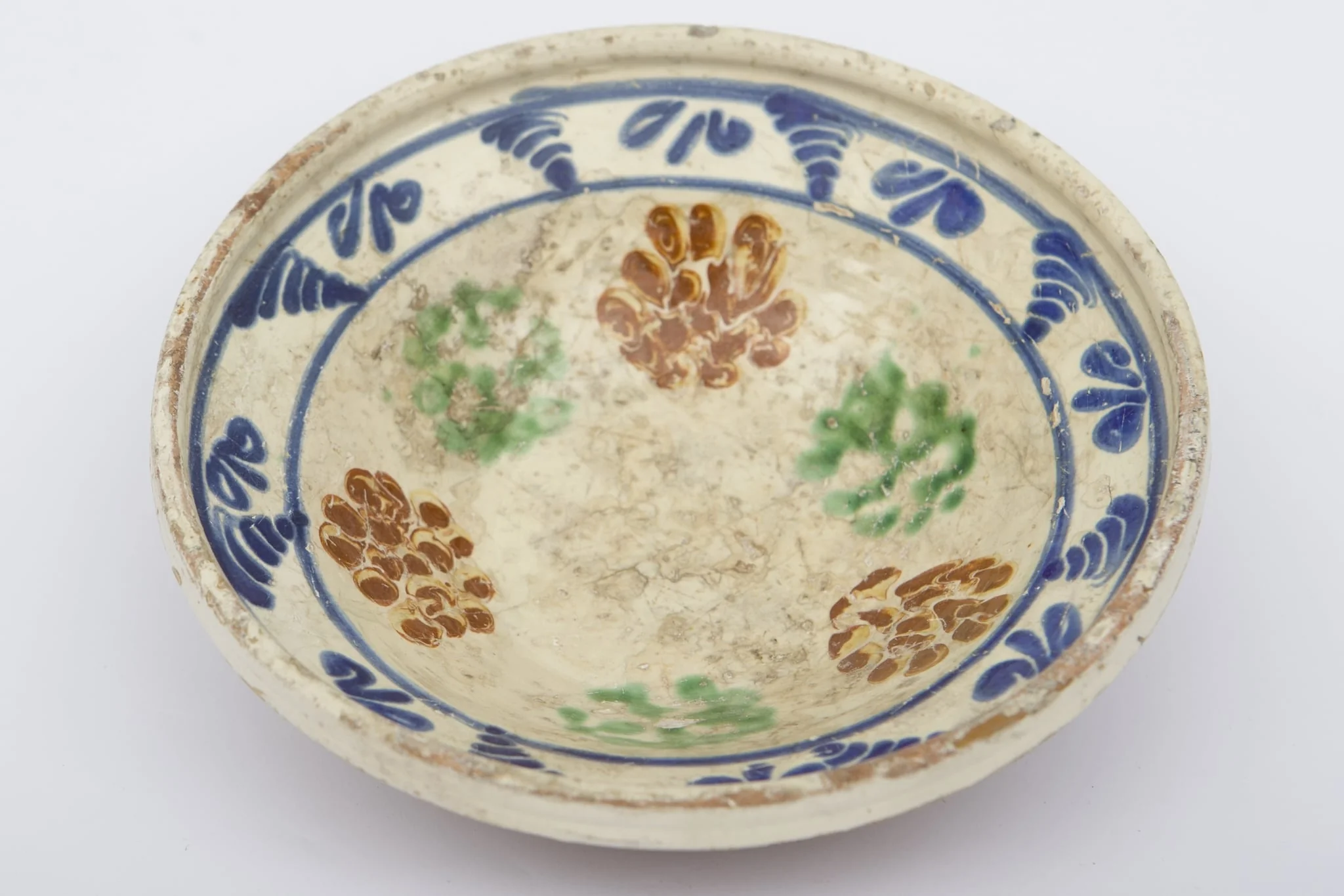 Vas ceramic de dimensiuni medii, smălțuit la interior, având formă tronconică. Blidul a fost decorat cu motive geometrizante și fitomorfe stilizate. Primul registru, dispus pe fundul piesei este format din șase flori verzi și maro, intercalate. Marginal, pe buza profilată a fost realizat cel de-al doilea registru, fiind trasate două linii circulare, care încadrează motive vegetale albastre, succesive. Blidul era folosit pentru servirea hranei. Prezintă uzură funcțională. Cromatică: fond: cărămiziu; crem; motive: albastru; maro; verde., by Unknown, unspecified, 1850