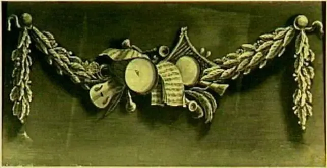 Decoratiestuk met een guirlande van muziekinstrumenten en bladmuziek